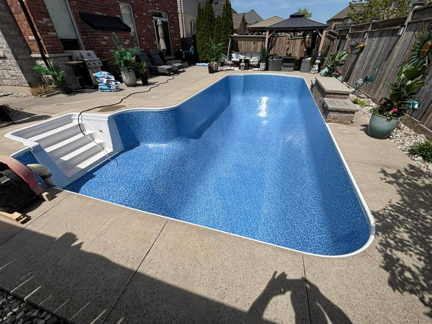 New blue vinyl liner and steps in a renovated inground pool