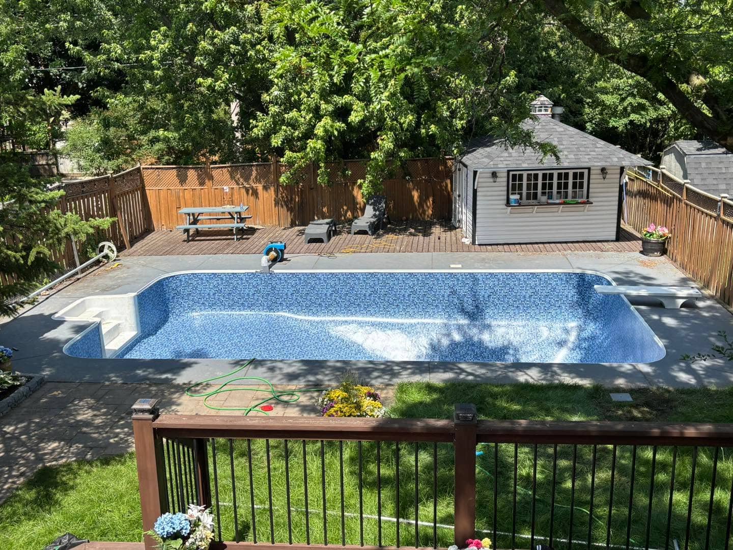 Backyard pool with a renovated wood deck surround